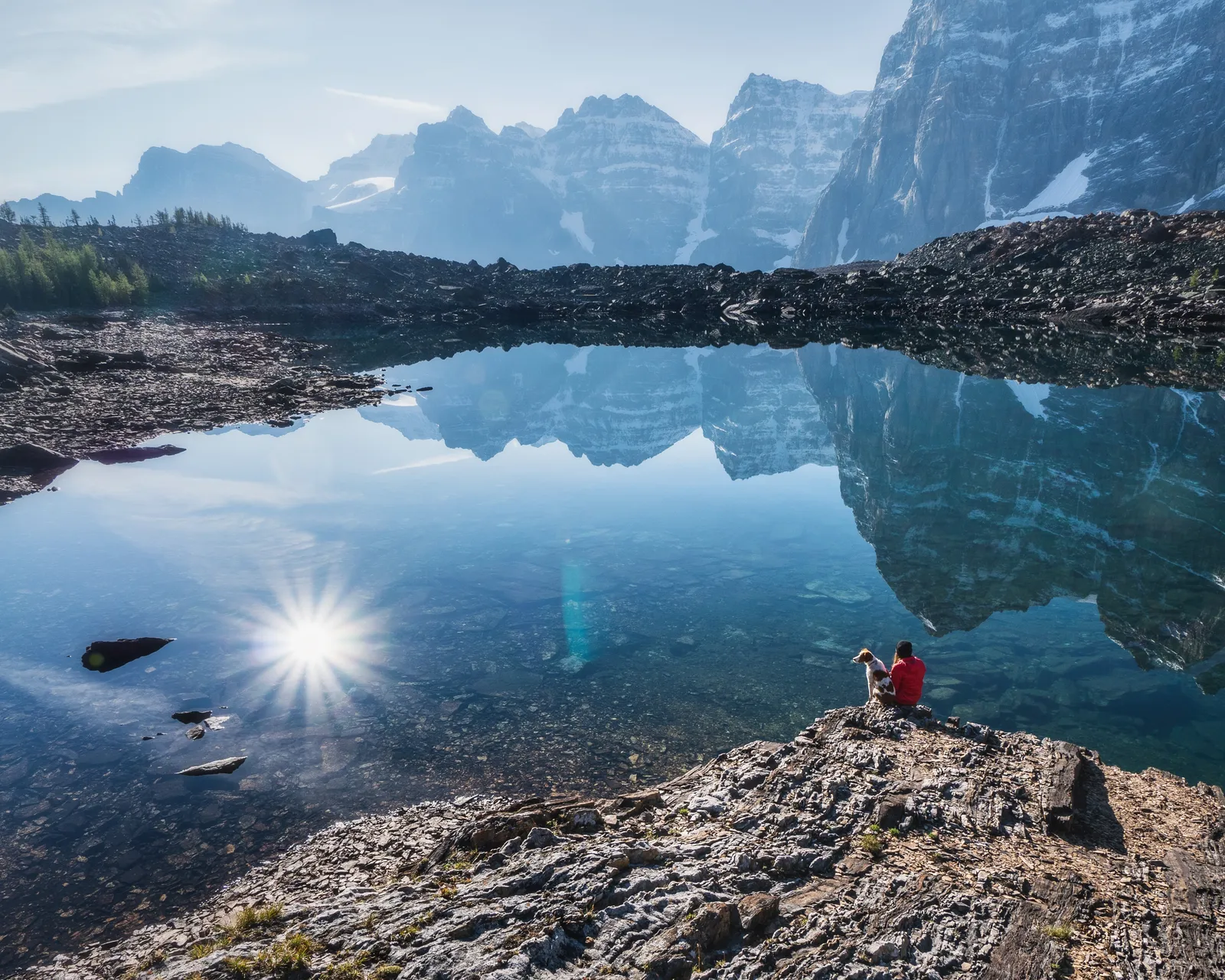 Human relaxes with dog near Eiffel Lake